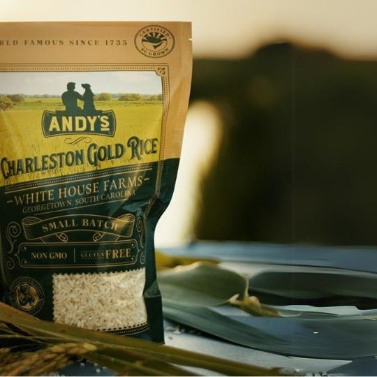 Bag of Charleston Gold Rice from Andy's White House Farms with seagrass basket full of rice against sunset at the farm